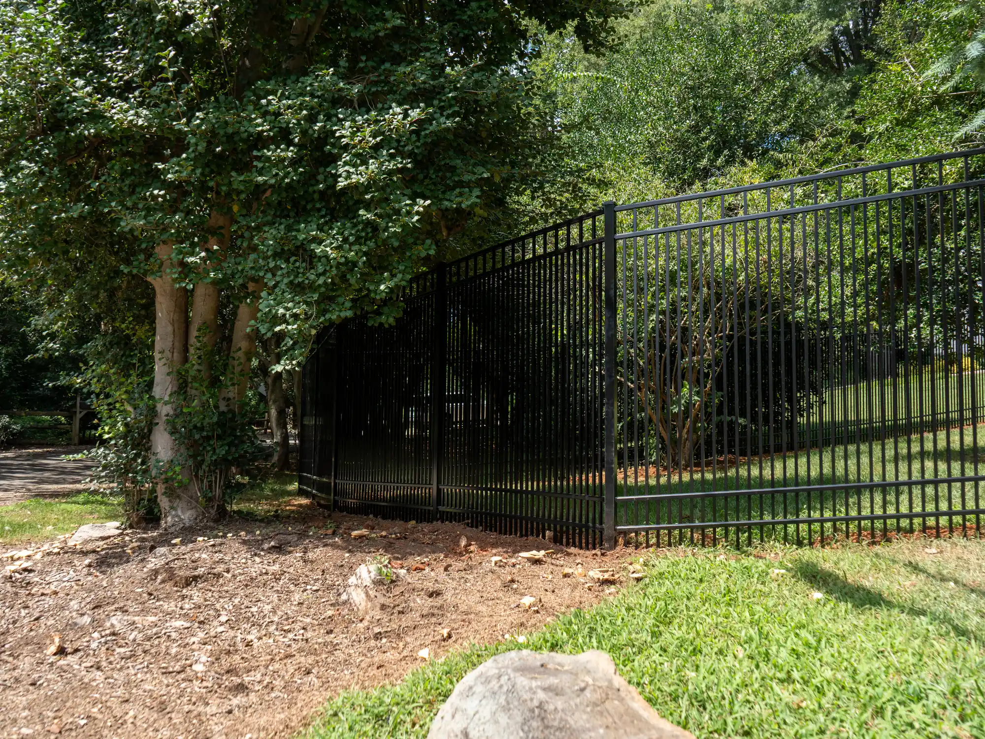 Long-lasting black aluminum fence curving along a mulched landscape bed at a Richmond home