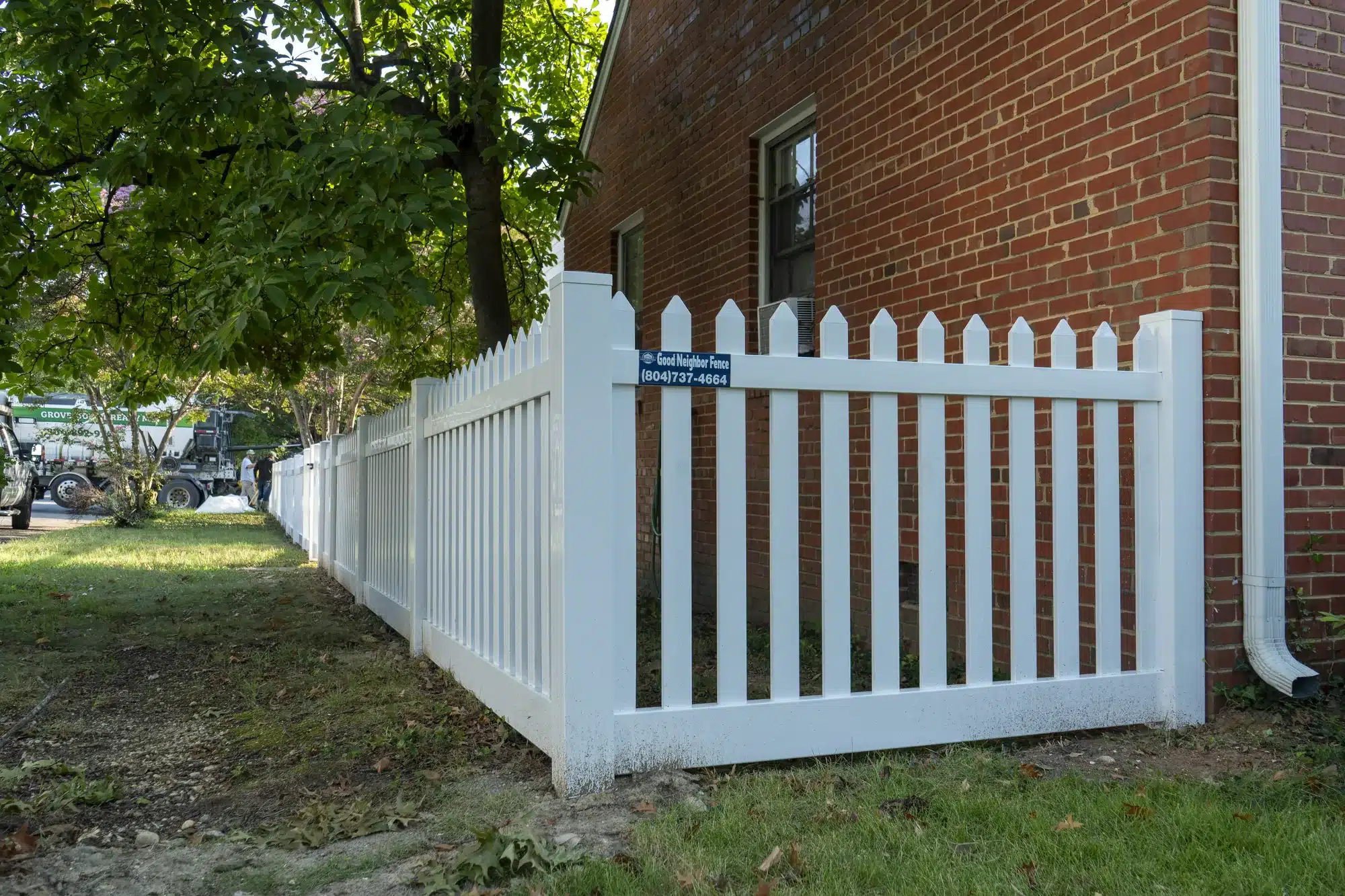 White front yard vinyl fence with French gothic pickets at the corner of a brick home in Richmond