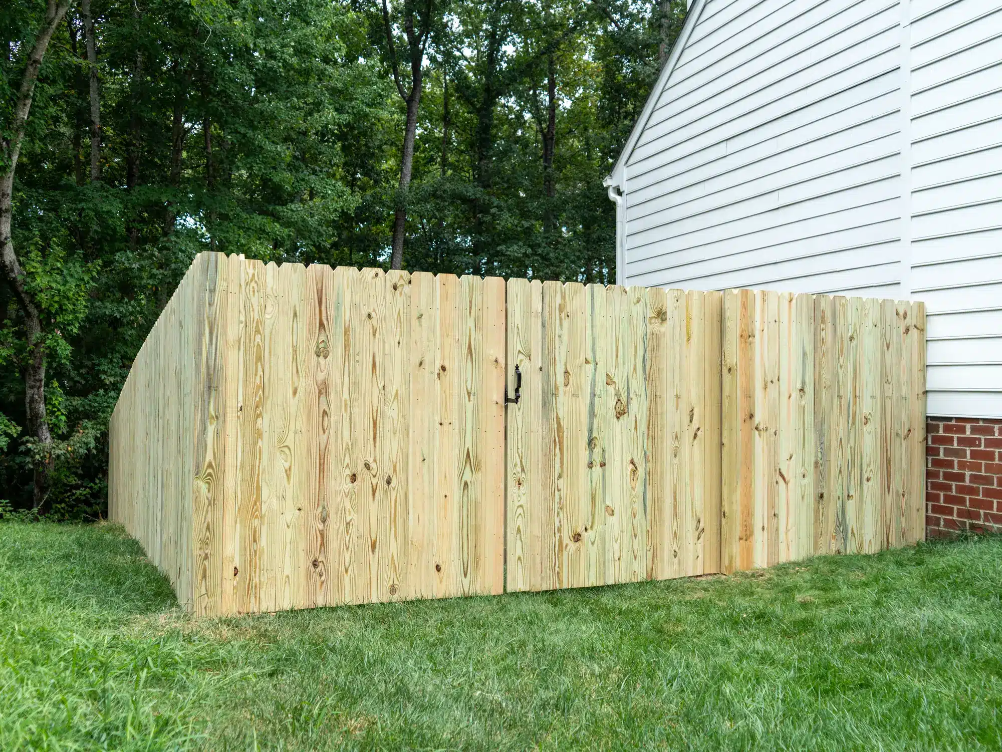 6-foot pressure-treated dog-ear privacy fence corner with a walk gate
