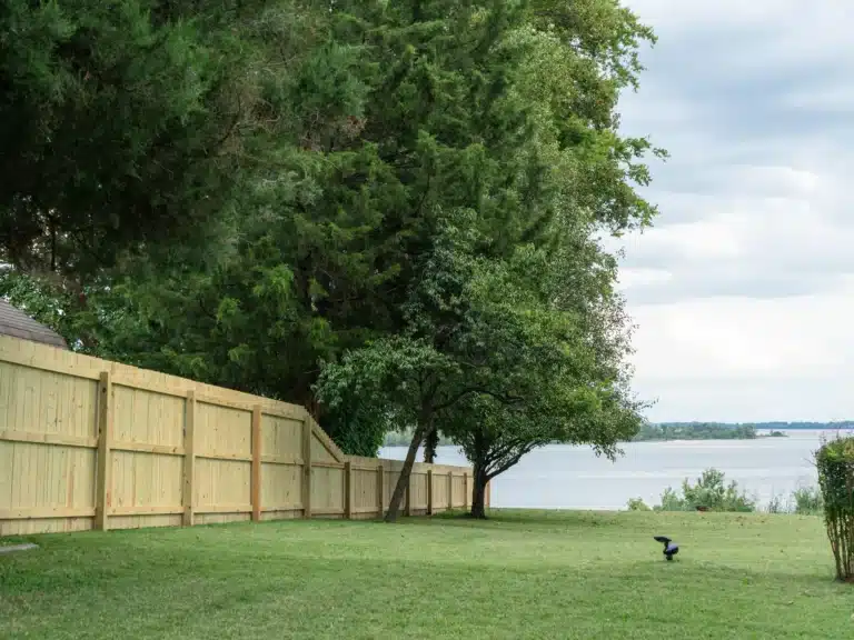 Wood side of a vinyl and wood fence in Hopewell, VA stepping down toward the river