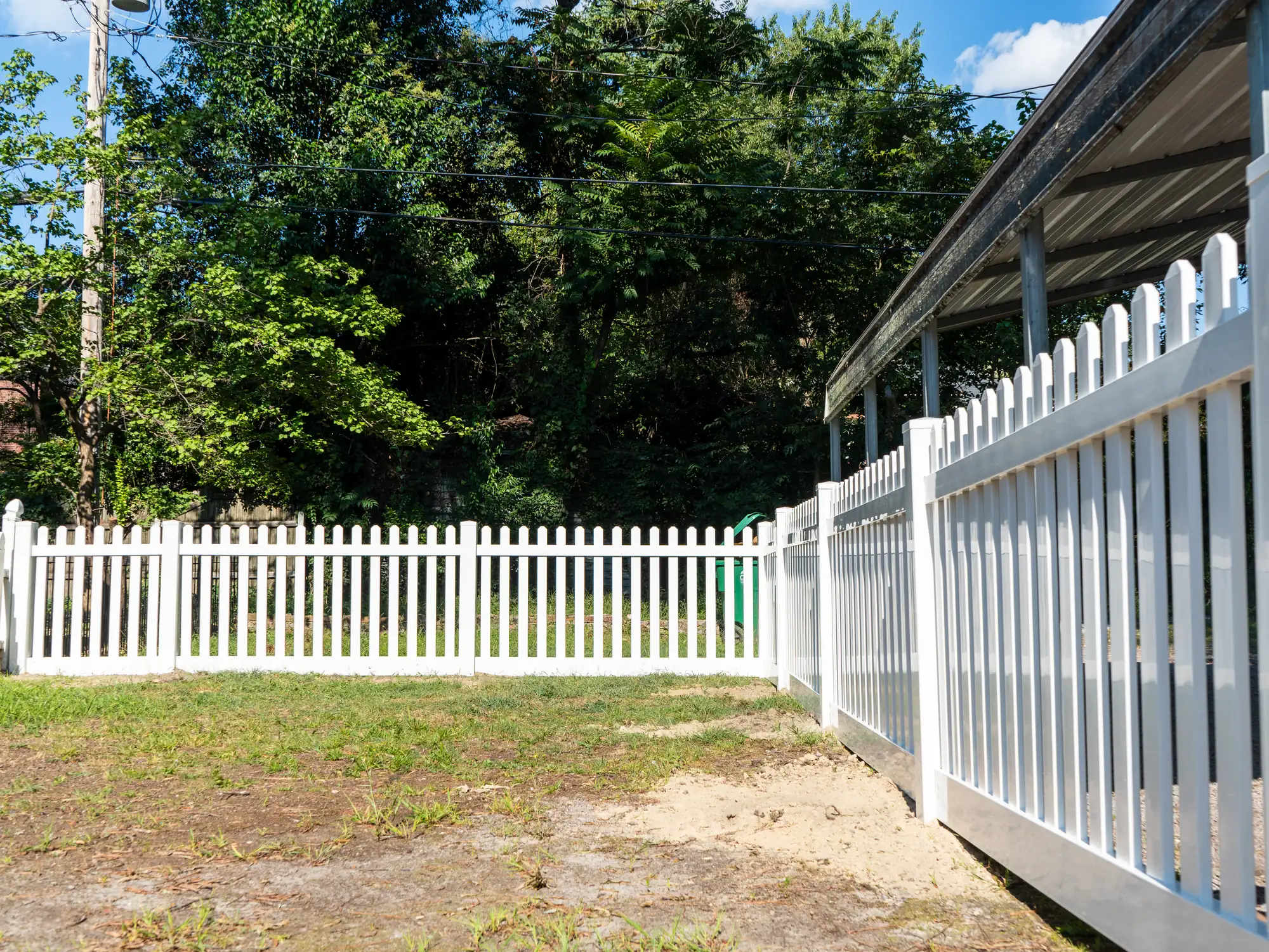 Vinyl picket fence in Hopewell, VA enclosing a backyard beside a covered porch