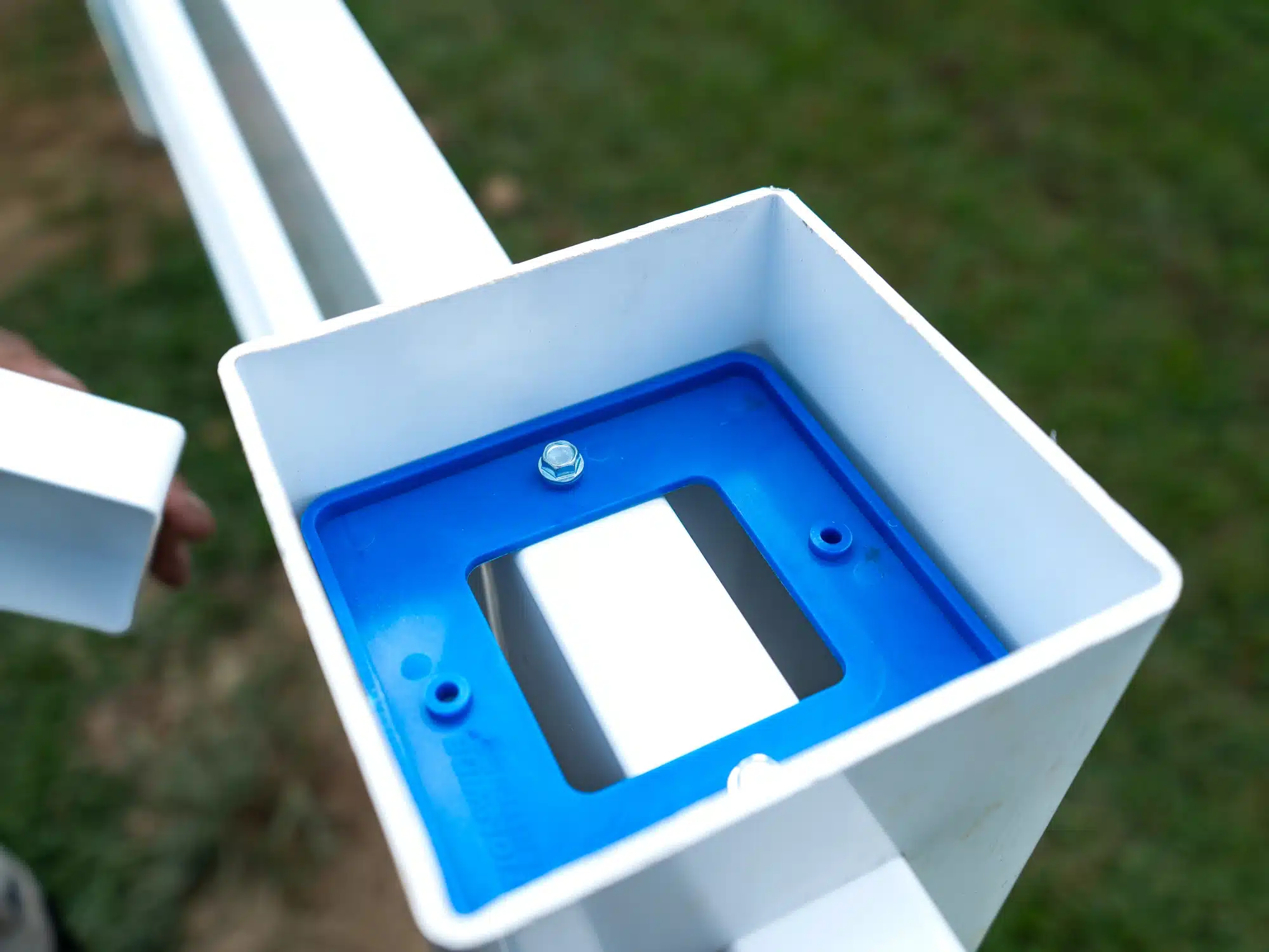 Blue rail bracket inside a white post, seen from above