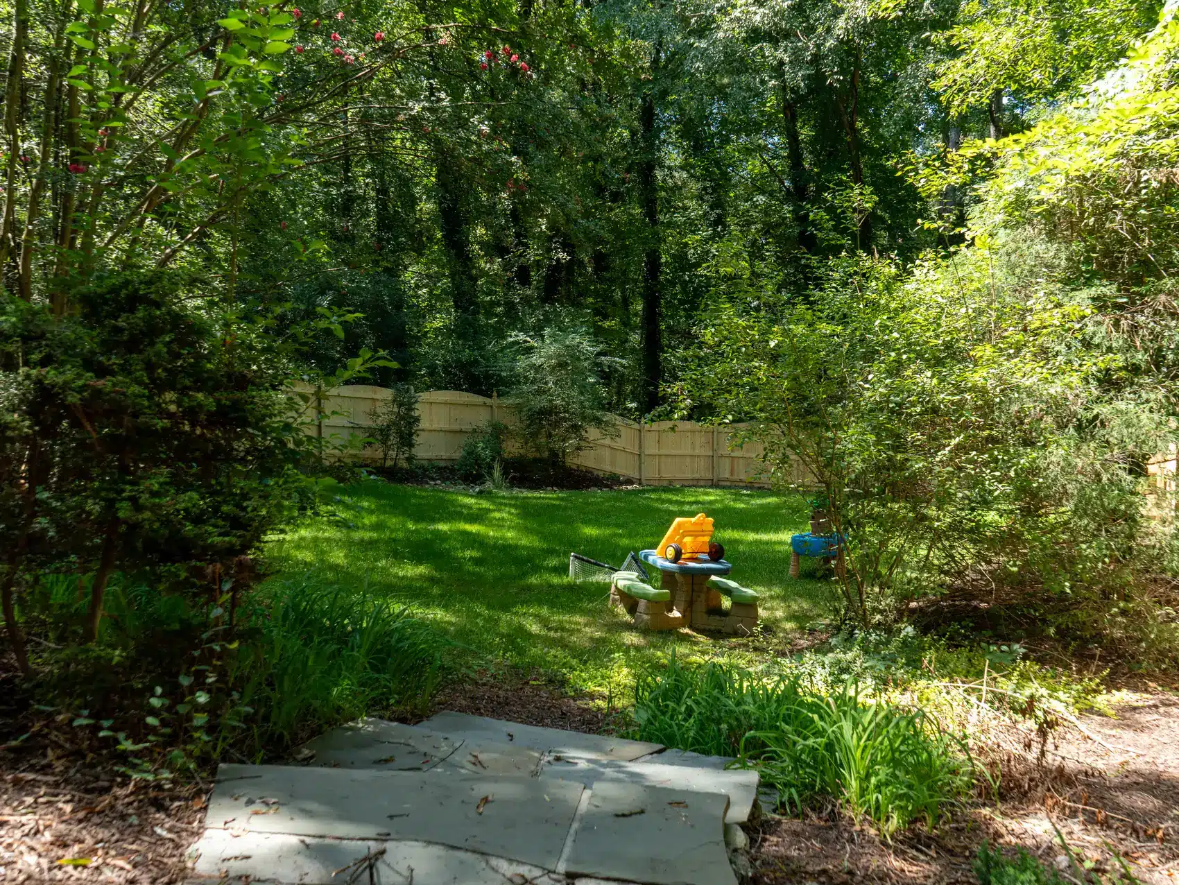 Wood privacy fence at the back of a wooded play yard in Henrico, VA